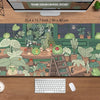 A large desk mat featuring a cute, green frog and various potted plants in a lush jungle setting.