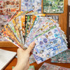 A hand holds a fan of Y2K aesthetic cut film stickers featuring various colorful and iridescent designs.