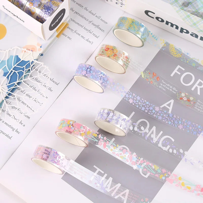 A set of decorative transparent washi tape rolls in various colors and patterns displayed on a white background.