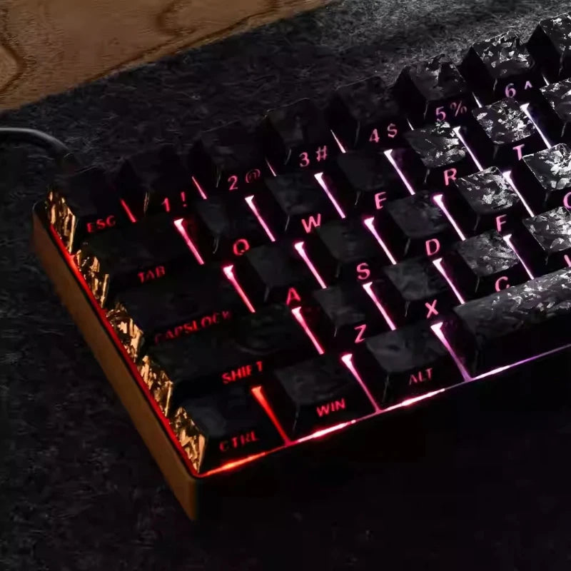 Close-up of a black mechanical keyboard with carbon fiber keycaps and side engraved backlit lettering.