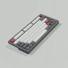 A close-up view of retro NES style PBT keycaps for mechanical keyboards, featuring various letter and function keys.