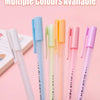 A collection of multiple colored glue pens, including blue, green, and yellow shades, displayed on a light pink background.