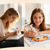 A young girl is painting a picture with an electric diamond painting pen on paper.