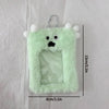 A light green plush holder shaped like a monster with white pom-poms and a clear window for a photocard.