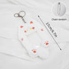 White plush photocard holder with paw prints and a chain, shown against a white fabric background.