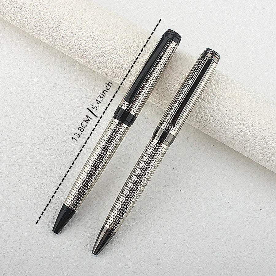 A silver metal ballpoint pen is shown diagonally on a white surface, with a measurement line indicating its length.