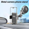 A metal camera phone stand mounted on a car windshield, featuring an articulating arm for stable viewing.