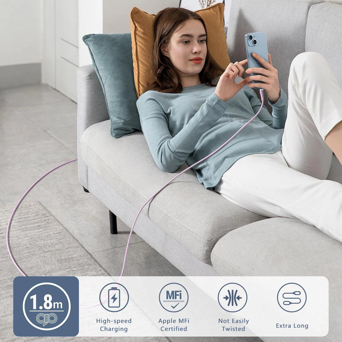 A woman is using a pink fast charging USB cable to charge an iPhone while relaxing on a sofa.