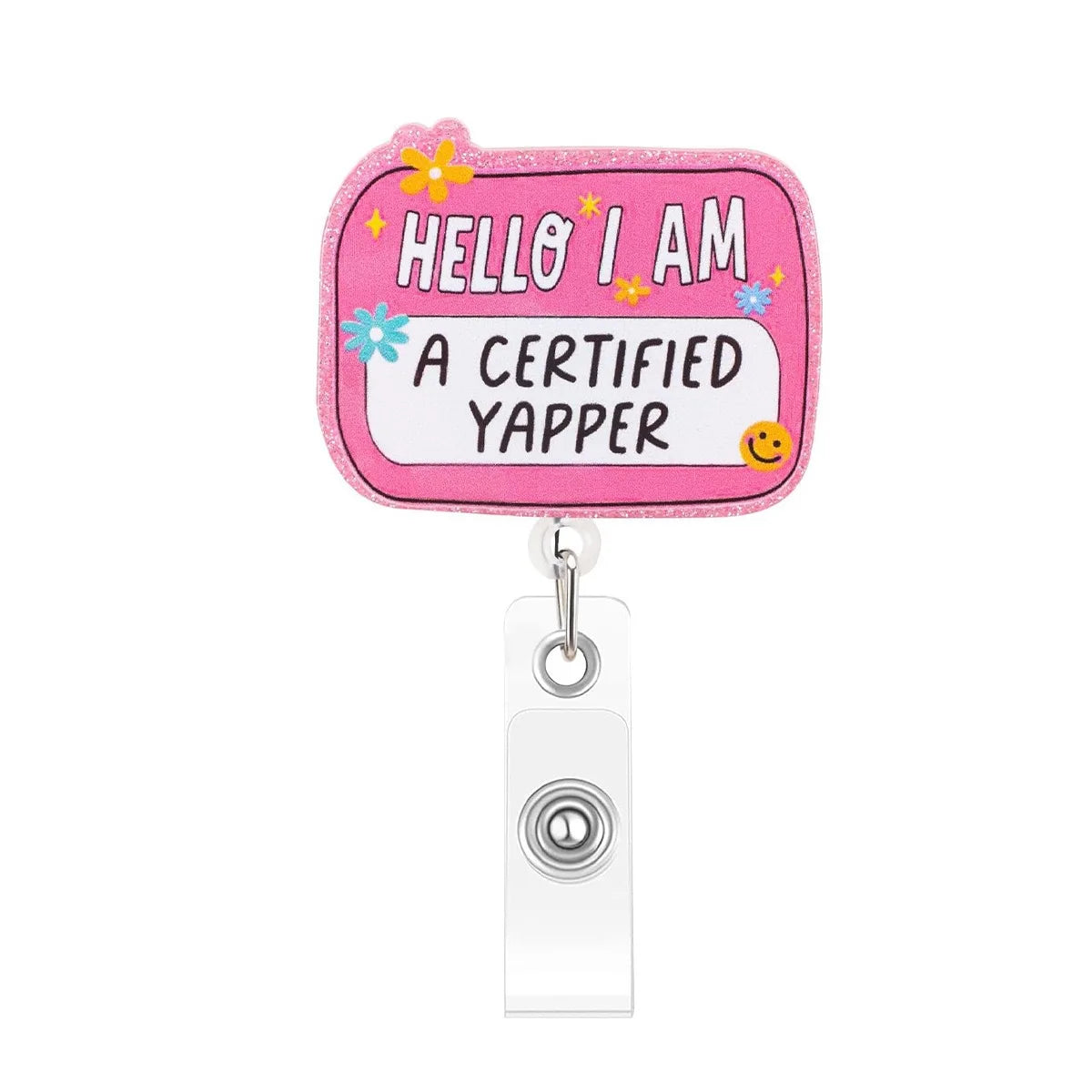 A pink badge reel charm shaped like a tag that says Hello I am a certified yapper with yellow flower accents.