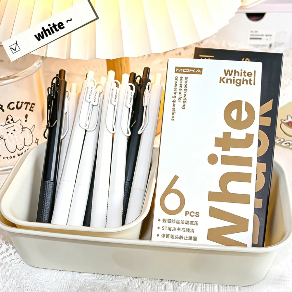 Une boîte blanche affichant un pack de six stylos gel noirs rétractables avec des accents dorés.
