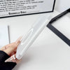 A hand holds a clear Samsung Galaxy Z Fold case with a magnetic hinge protection feature on a white surface.