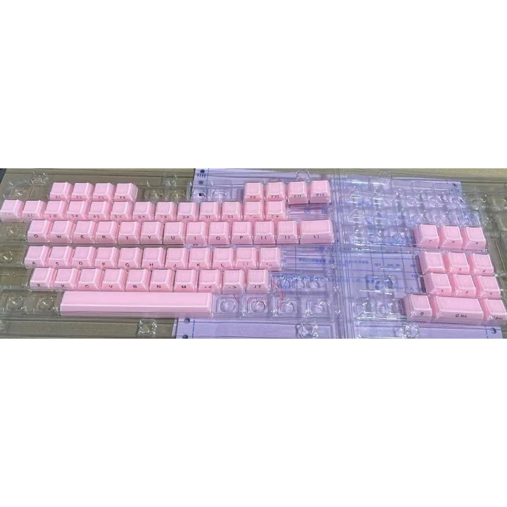 Custom printed pink jelly keycaps arranged in rows on a clear plastic sheet.