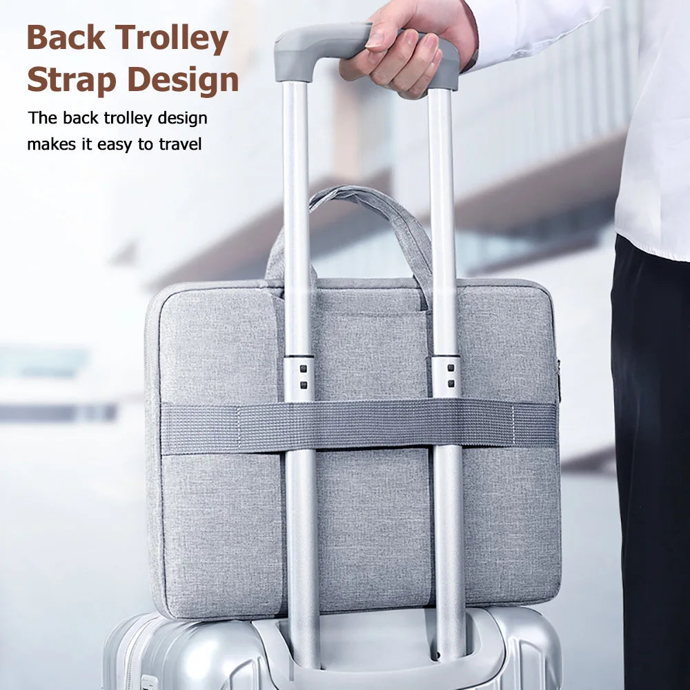 A silver laptop bag with a black strap design is shown being held by a hand.