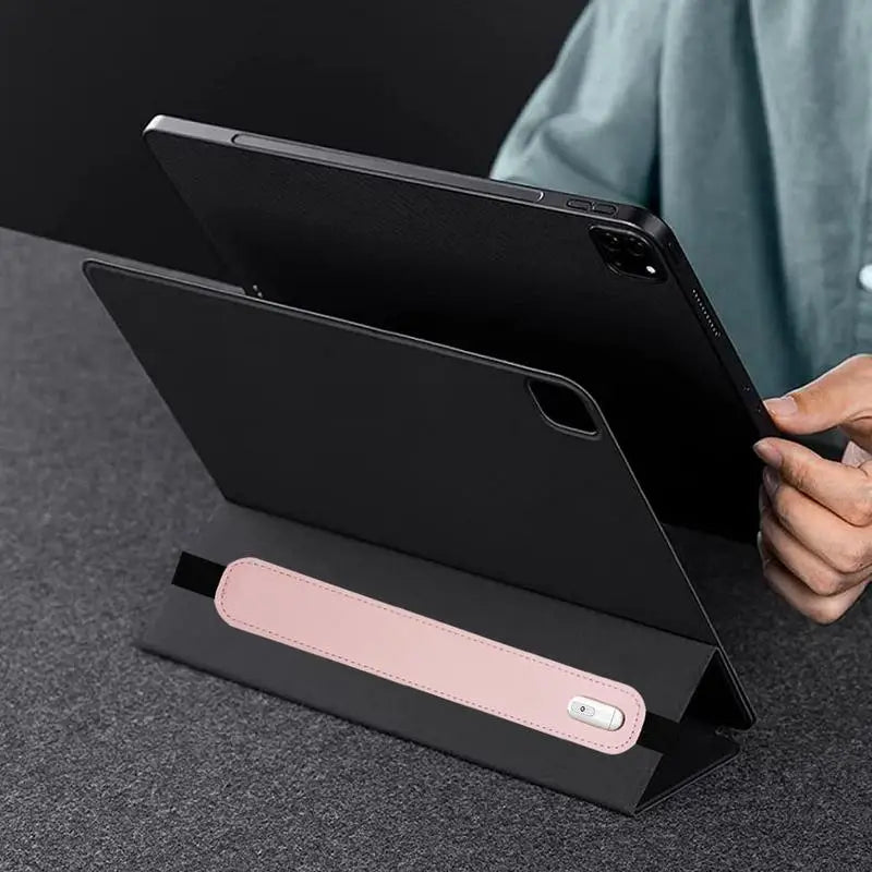 A black leather protective case is shown with a tablet and stylus inside, resting on a dark surface.