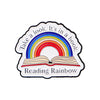 Enamel lapel pin featuring a rainbow arching over an open book with the text Take a look It's in a book Reading Rainbow