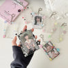 Une main tient un pendentif porte-photocard en acrylique avec une photo de personne, entouré de petits charms en forme d'étoi