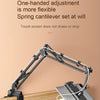 A black spring cantilever set at will adjustable tablet holder with a long arm positioned on a wooden surface.