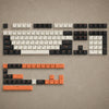 A close-up view of a full 168-key PBT double shot mechanical keyboard with cherry profile keycaps and orange accents.