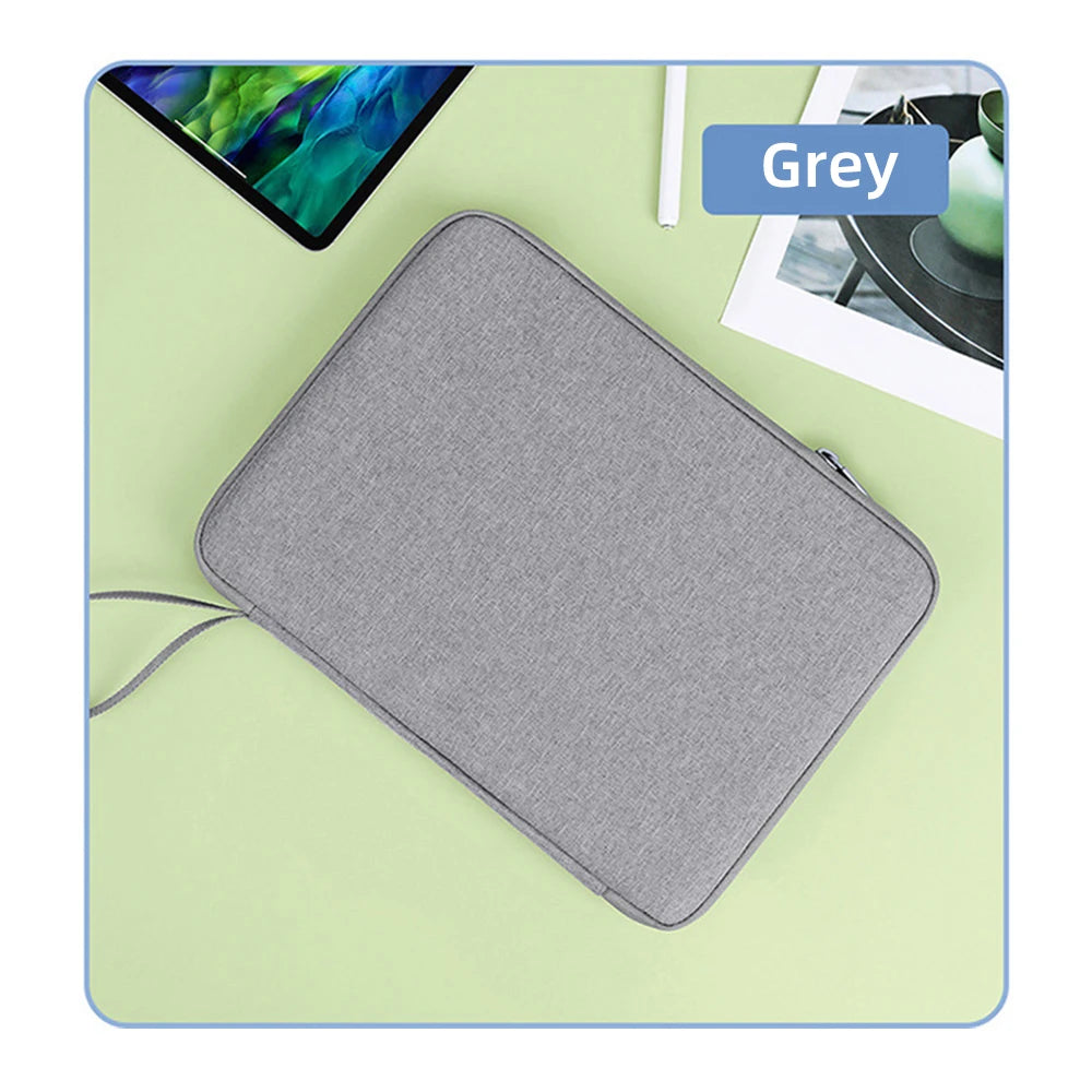 Graues universelles Tablet-Etui auf helgrüner Oberfläche neben einem Tablet und einem Foto