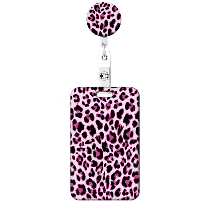 A pink leopard print retractable badge holder with a circular charm.