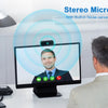 A computer screen shows a man with a green indicator light, demonstrating a stereo microphone setup for video calls.
