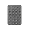 A gray reusable silicone suction phone mount with multiple circular holes for mounting.