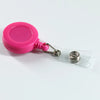 Porta credencial de plástico rosa con clip metálico y cordón unido a un soporte de tarjeta de plástico transparente.