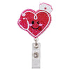 A heart-shaped, glittery red badge reel holder with a cartoon face and a small cross.