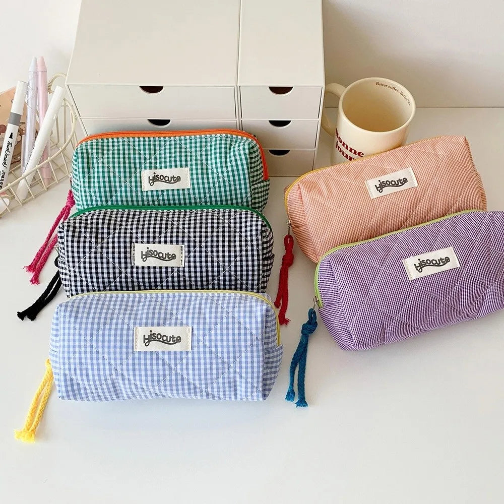 A collection of colorful zippered pencil cases in various patterns and colors, resting on a white surface.