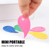A hand is holding a pink mini portable plastic box opener and cutting tool alongside other colored tools.