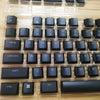 A close-up view of a black mechanical keyboard featuring various keycaps and switches.