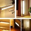 A motion sensor LED night light is mounted on a wall, illuminating a room.