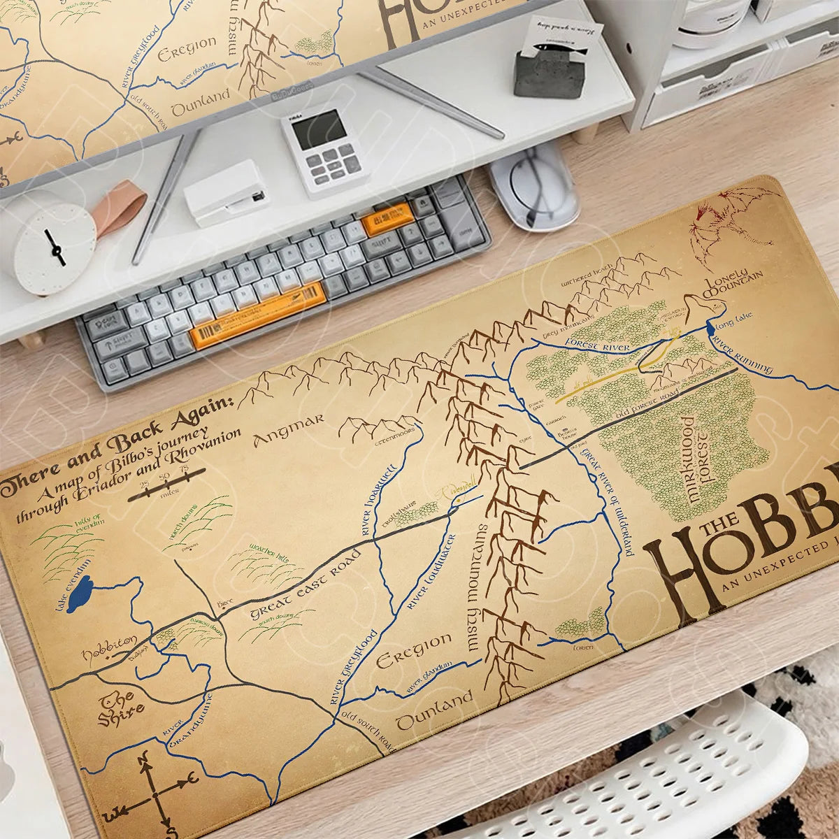 A large map of Middle-earth featuring various locations and terrain is displayed next to a gaming mouse pad desk mat.