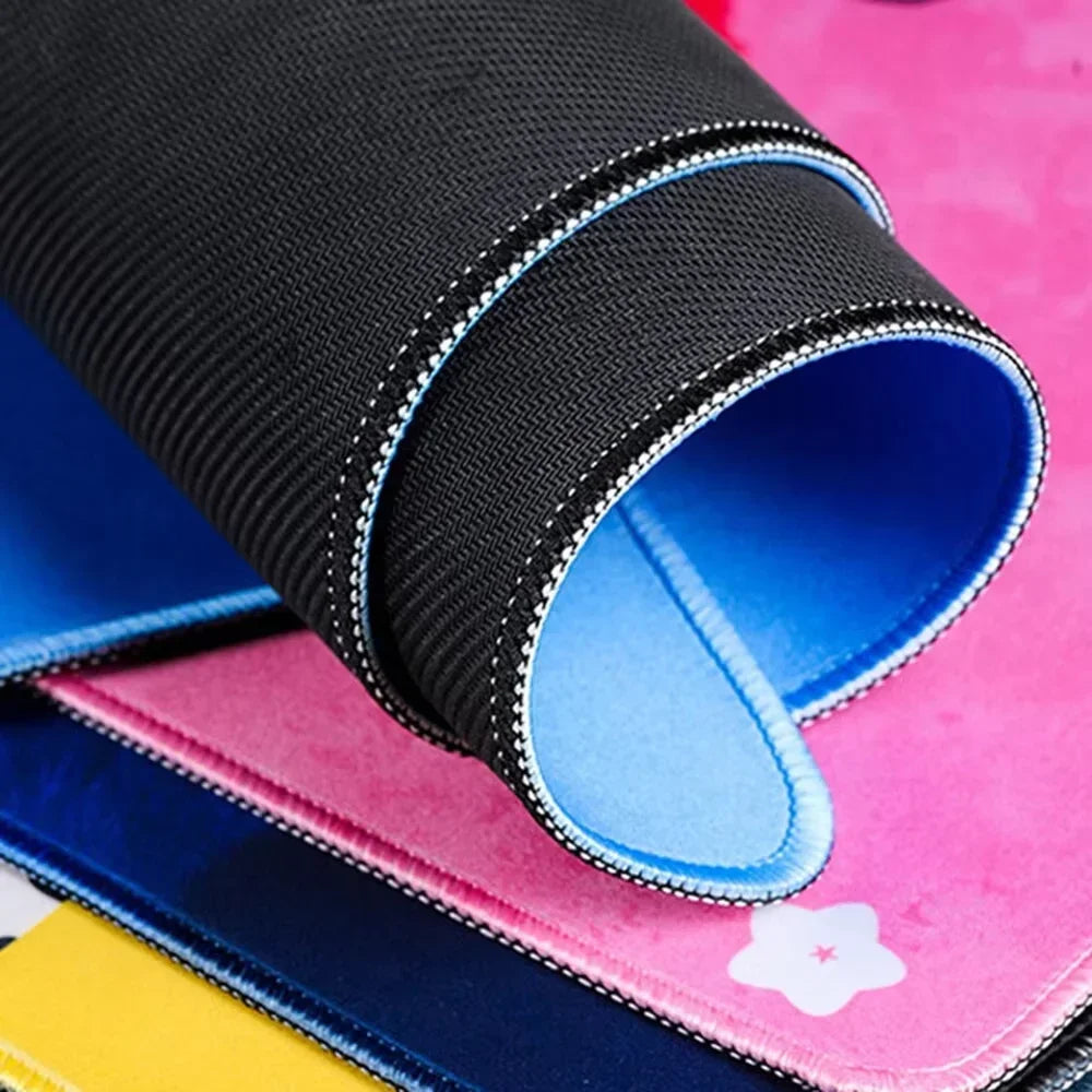 A black overlocked mouse pad is shown rolled up, resting on a stack of colorful pads.