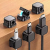 Six magnetic cable organizer clips in black and white are shown on a wooden surface.