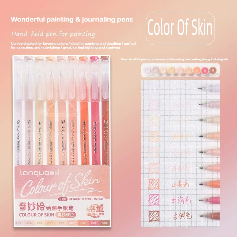 A set of hand-held painting and journaling pens in various shades of skin tones, displayed next to a grid paper.