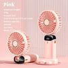 Un ventilador mini portátil rosa con una red desmontable, apoyado en un soporte.