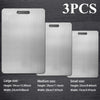 A set of three stainless steel double-sided cutting boards in large, medium, and small sizes.