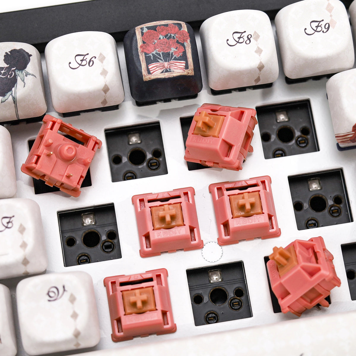 A close-up view of various rosewood linear mechanical keyboard switches in white and pink colors.