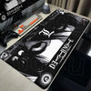 Black Death Note XXL mouse pad with a stylized skull design placed on a desk next to a keyboard.