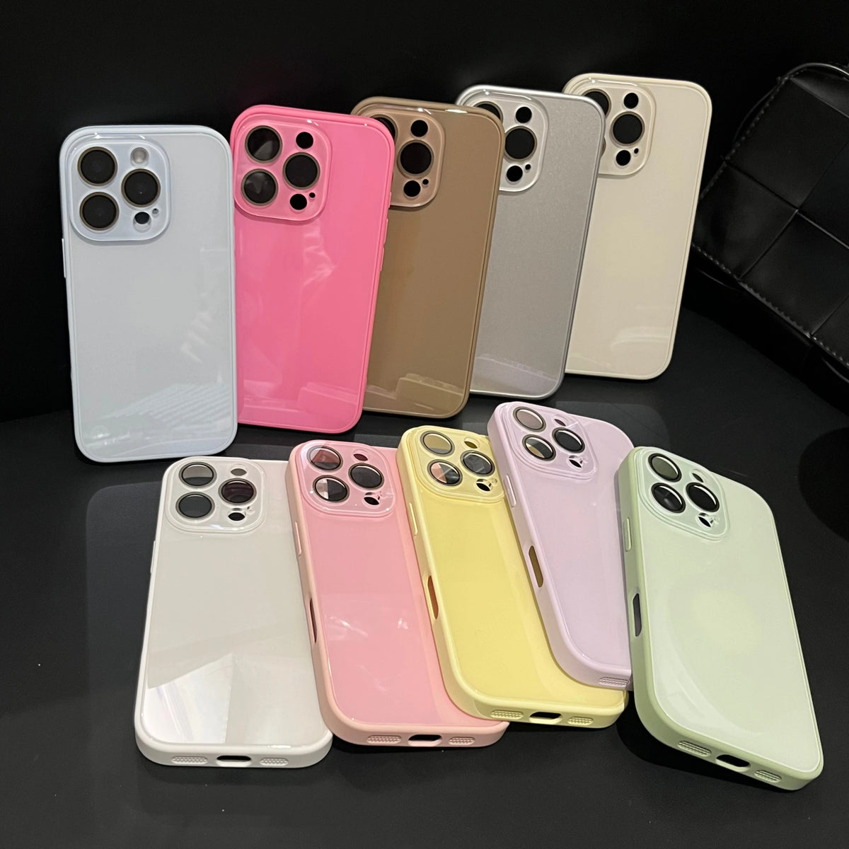 A collection of various colored glossy tempered glass shockproof cases for iPhone phones.