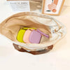Beige Silikon-Kosmetiktasche mit Armgurt, offen und mit mehreren pastellfarbenen Make-up-Beuteln gefüllt.