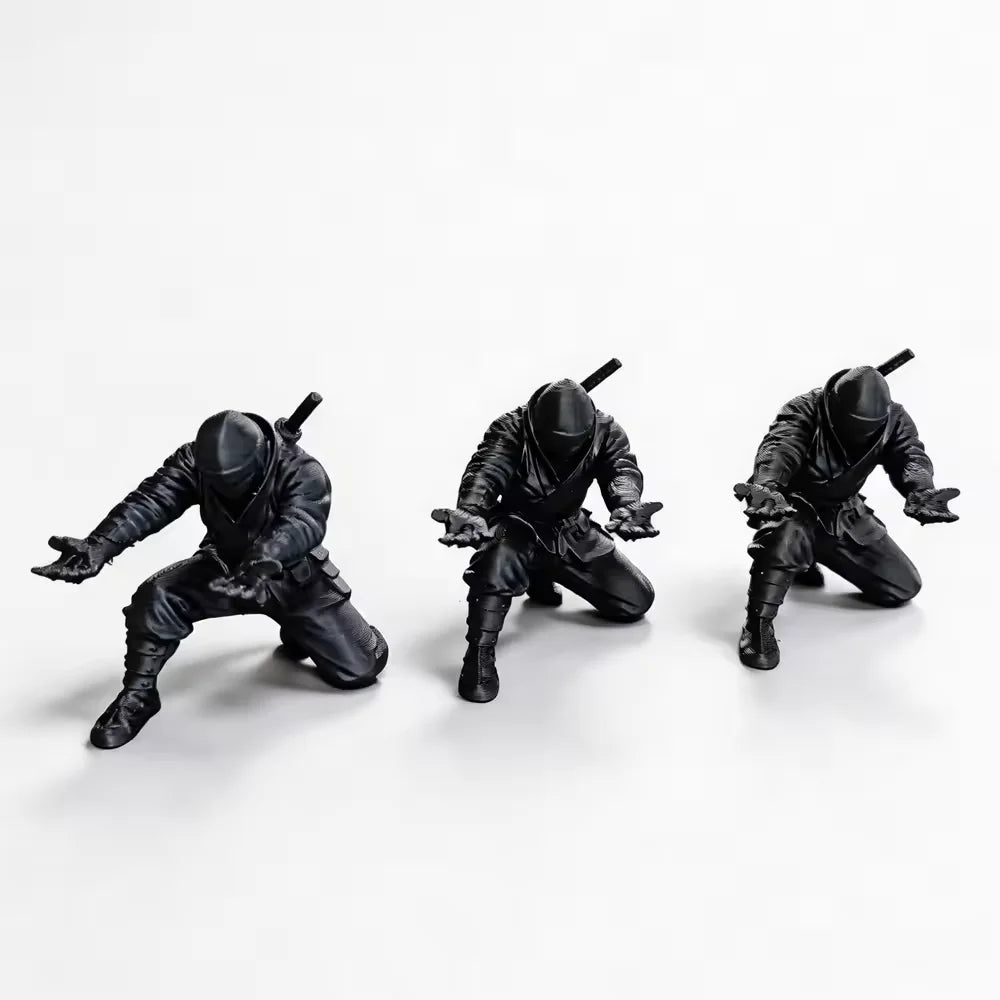 Matte black ninja figurine pen holder in a dynamic pose against a white background