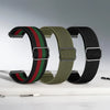 Three adjustable elastic sports bands in green, red, and black stacked on a white surface.
