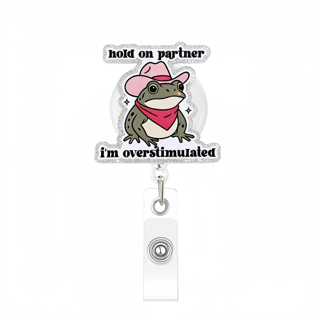 A clear acrylic nurse badge reel featuring a frog wearing a pink hat and a red bandana with text that reads I'm overstimulate