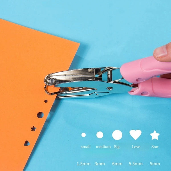 A hand holding a pink metal puncher tool next to an orange cardstock with various sized holes.