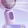 Nahaufnahme eines lila, tragbaren USB-Ladebaren Mini-Ventilators mit rotierbarem Gitter und Stromanzeige.