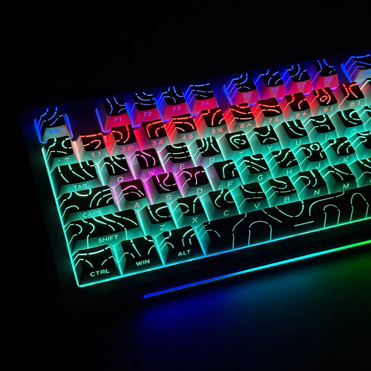 Primer plano de un teclado mecánico con teclas con degradado brillante y luces RGB coloridas.