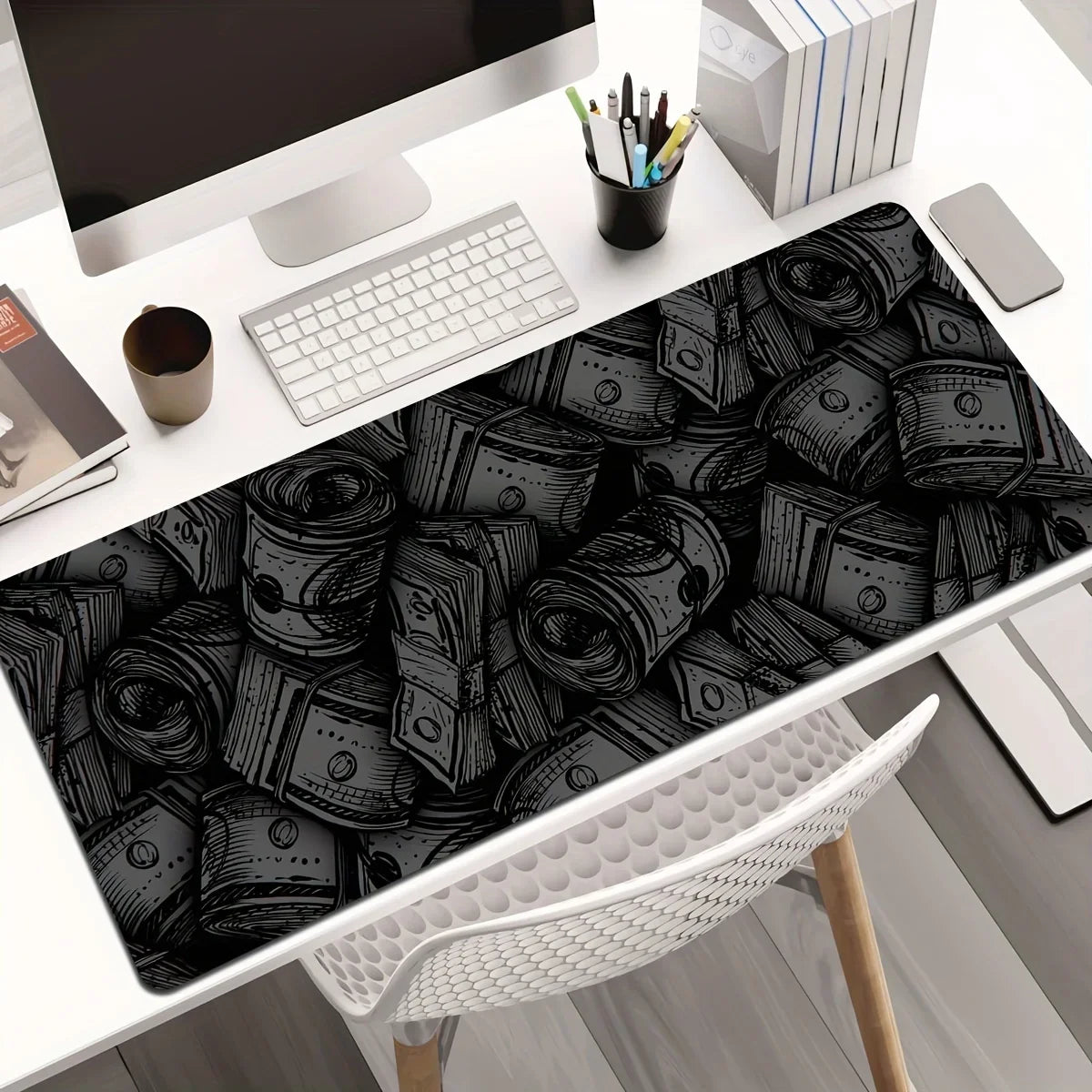 A black desk mat featuring a pattern of rolled-up paper scrolls on a white desk.