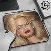 A realistic doll face mouse pad featuring blonde hair and makeup, shown next to a computer mouse.